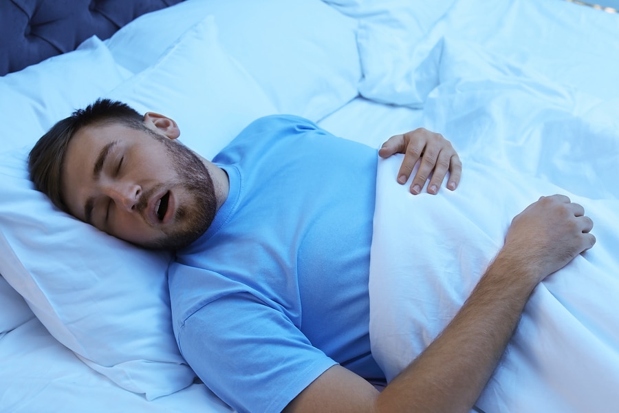 picture of a bearded man sleeping with his mouth open, apnea affects oral health.